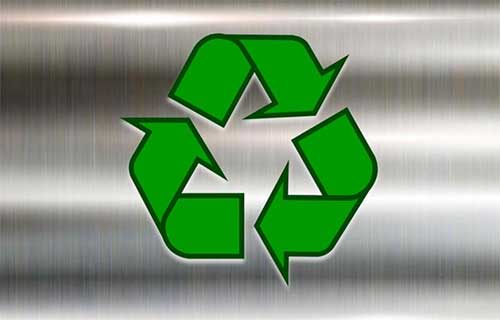 3 green arrows pointing towards each other shaped in a triangle, commonly known as the “recycle” symbol, on a shiny steel background.