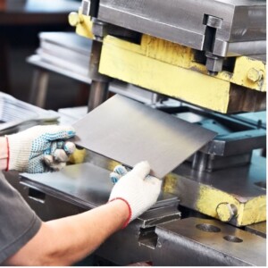 Worker operating a metal sheet press machine