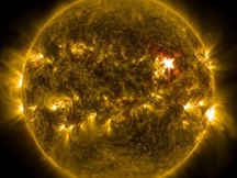 Filtered in yellow is a close-up view of the Sun with solar flares shooting out of the pitch-black background.